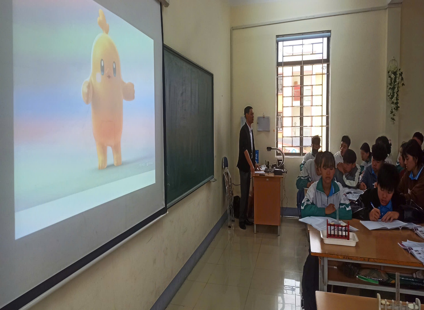 'A person standing in front of a projector screen

Description automatically generated'